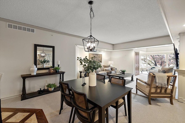 dining area featuring a textured ceiling, ornamental molding, visible vents, and light colored carpet