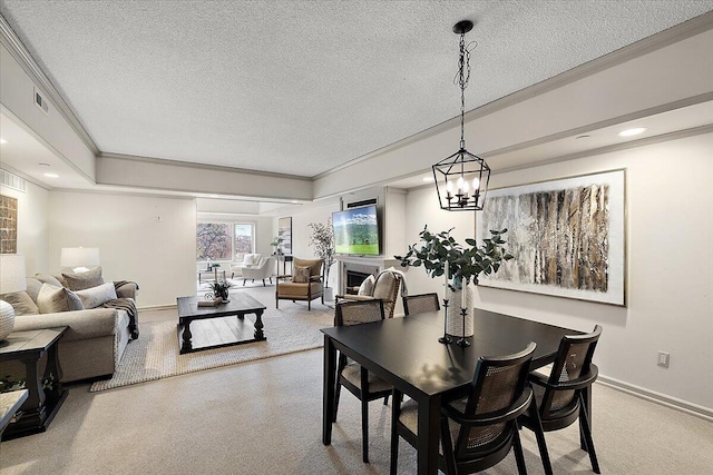 dining area featuring crown molding, a fireplace, baseboards, and a textured ceiling