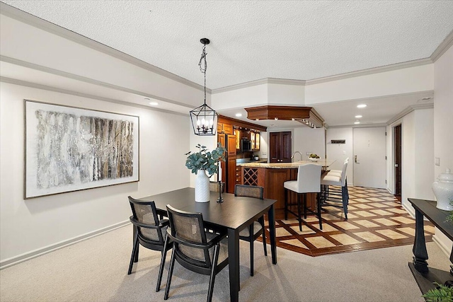 dining room with a textured ceiling, ornamental molding, recessed lighting, and light colored carpet