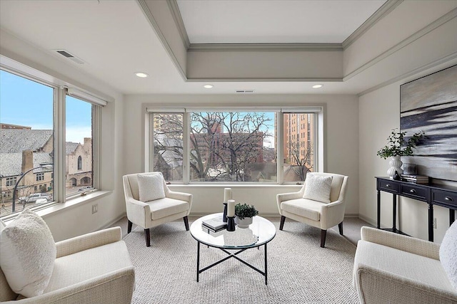 sitting room featuring a tray ceiling, visible vents, ornamental molding, carpet flooring, and baseboards