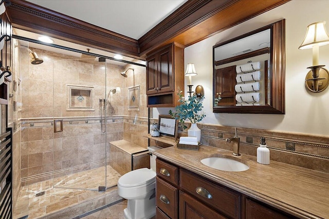 bathroom with toilet, a shower stall, ornamental molding, and vanity