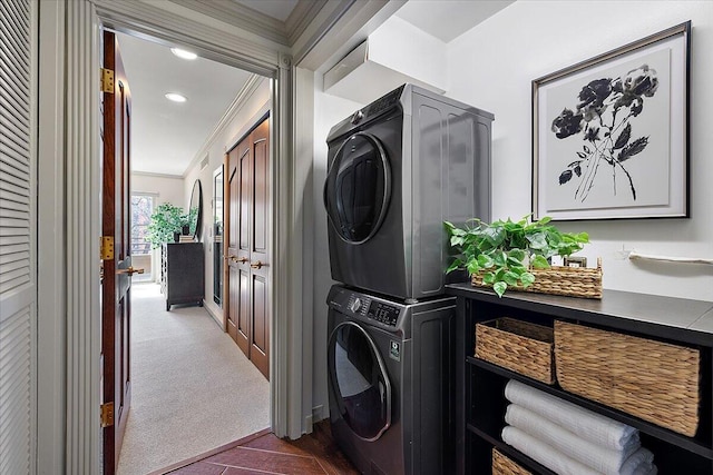 laundry room with recessed lighting, stacked washer and dryer, laundry area, dark colored carpet, and crown molding