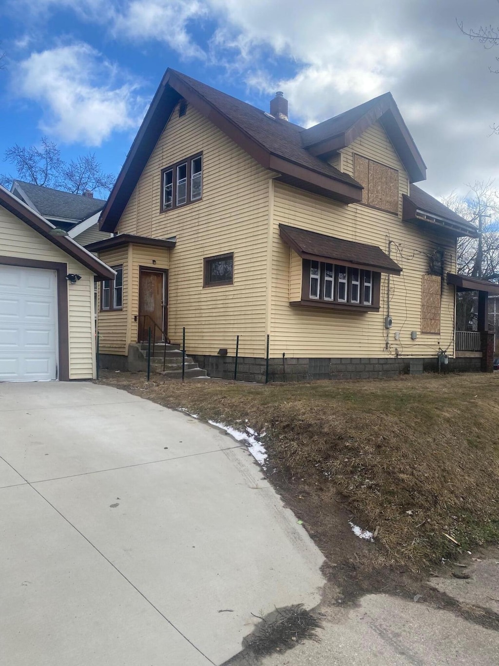 view of front of house with a garage, a chimney, and concrete driveway