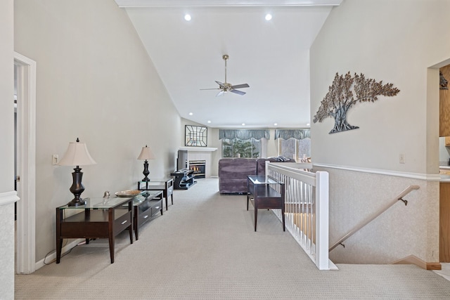 hallway with high vaulted ceiling, recessed lighting, light colored carpet, and an upstairs landing