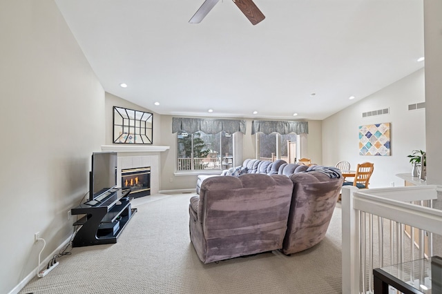 carpeted living area with vaulted ceiling, a fireplace, visible vents, and recessed lighting