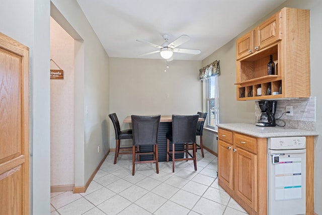 dining area featuring light tile patterned floors, baseboards, and a ceiling fan