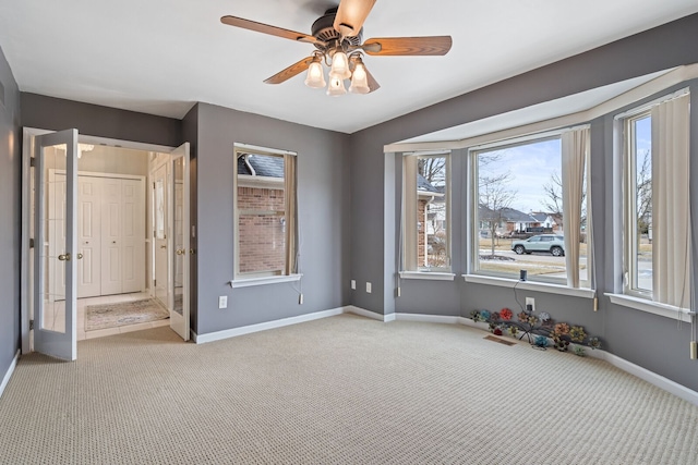 unfurnished bedroom featuring light carpet, ceiling fan, and baseboards