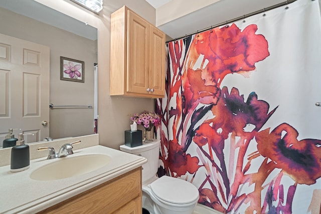 bathroom featuring a shower with curtain, vanity, and toilet