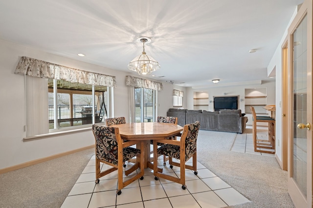 dining area featuring baseboards, a notable chandelier, and light colored carpet