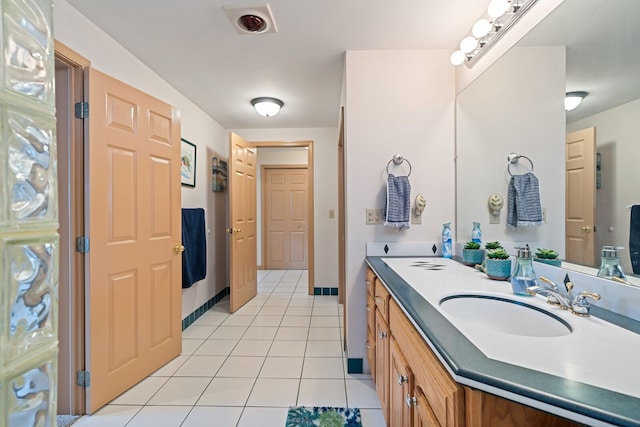 bathroom featuring tile patterned flooring, vanity, and baseboards