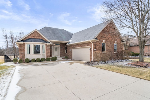 view of front facade with a garage, concrete driveway, brick siding, and a shingled roof