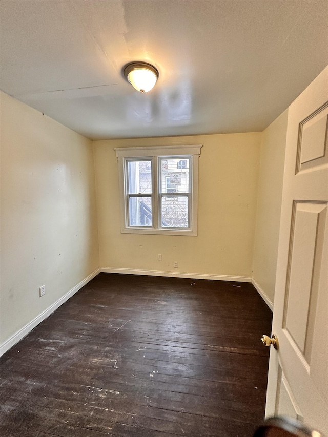 empty room with baseboards and hardwood / wood-style floors