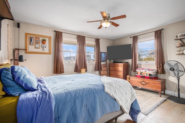 bedroom with ceiling fan, wood finished floors, and baseboards