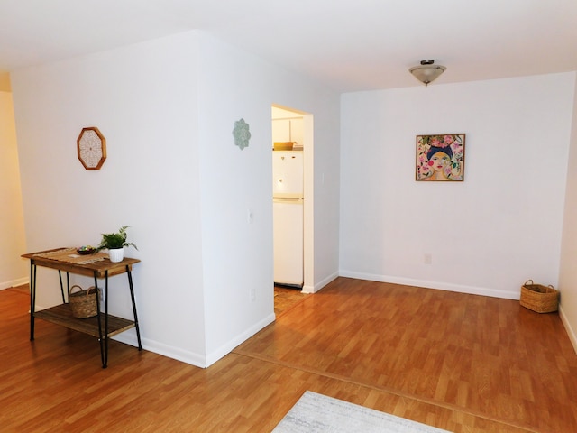 spare room with light wood-type flooring and baseboards