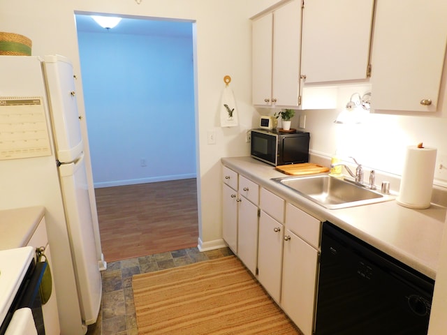 kitchen featuring stove, a sink, light countertops, freestanding refrigerator, and dishwasher