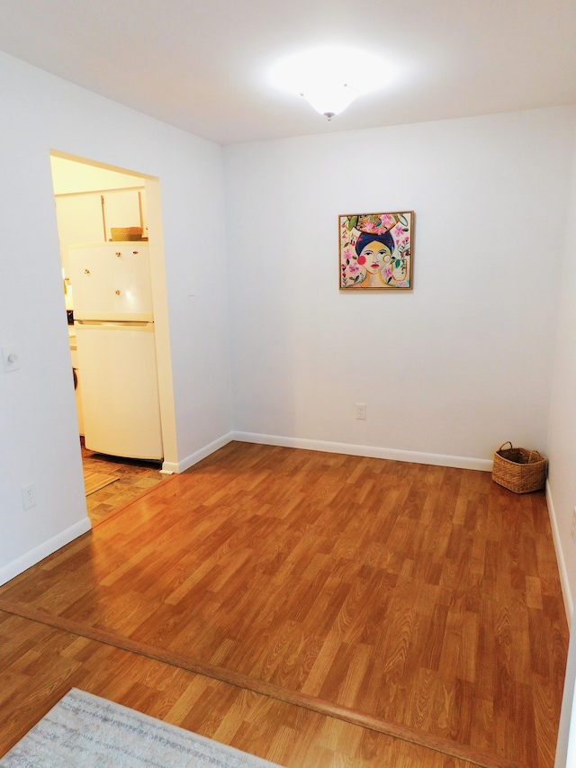 empty room featuring baseboards and wood finished floors