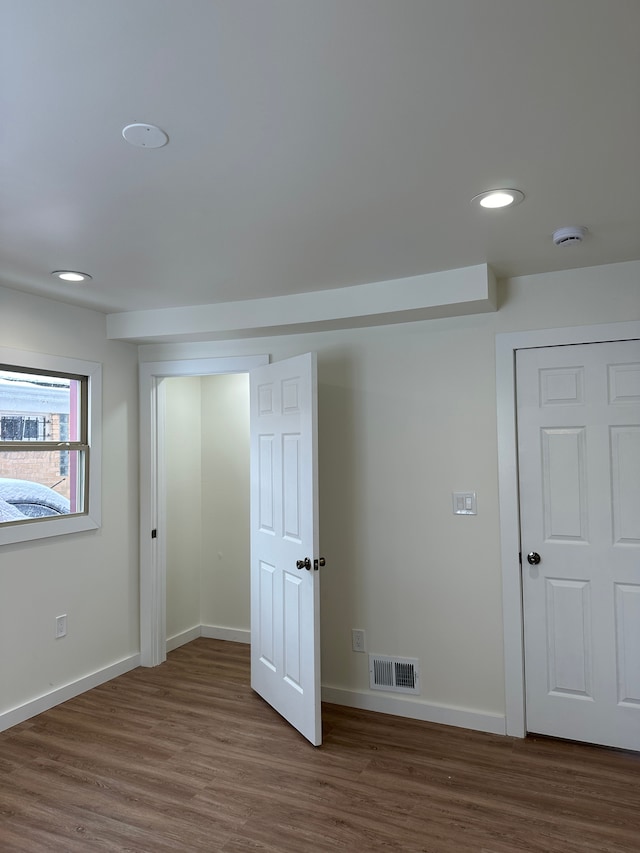 unfurnished bedroom featuring dark wood-style floors, recessed lighting, visible vents, and baseboards