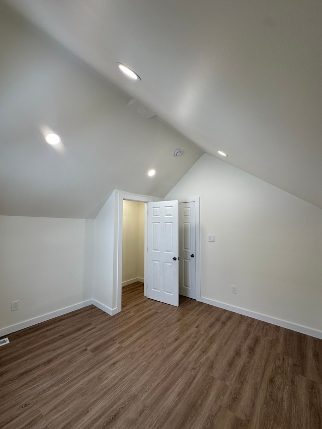 bonus room with lofted ceiling, baseboards, visible vents, recessed lighting, and dark wood-style flooring