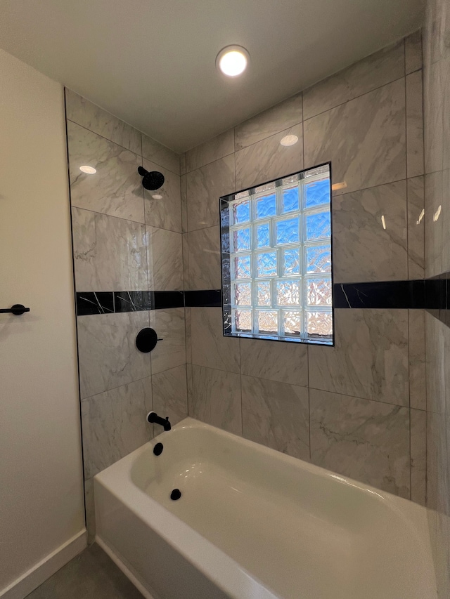 bathroom featuring baseboards and bathtub / shower combination