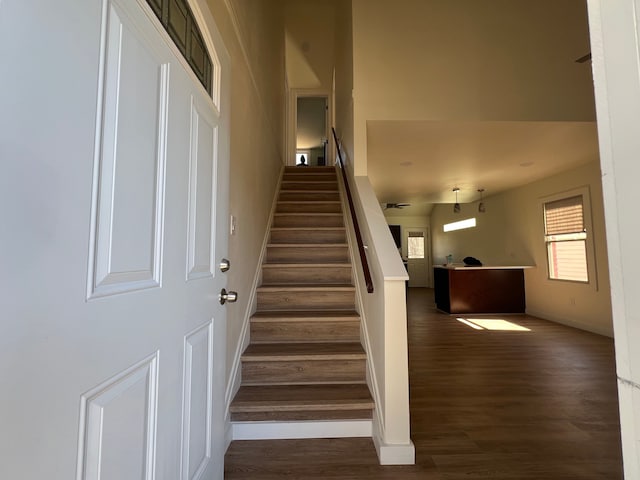 staircase featuring baseboards and wood finished floors