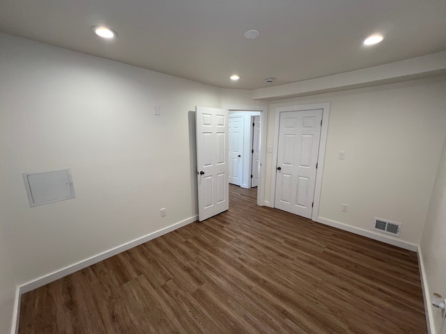 unfurnished room featuring dark wood finished floors, baseboards, visible vents, and recessed lighting