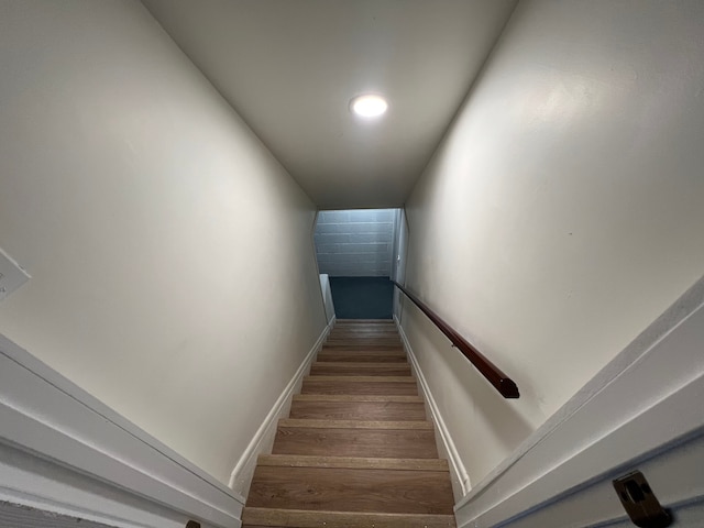 stairway featuring baseboards and wood finished floors