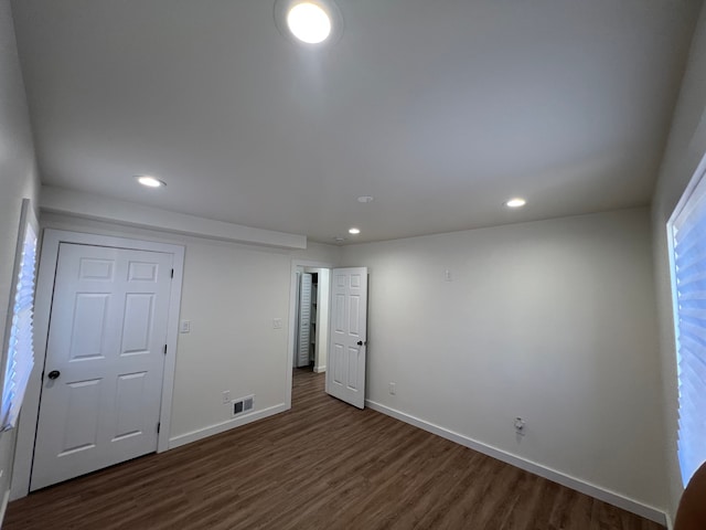 spare room featuring baseboards, dark wood-style floors, visible vents, and recessed lighting