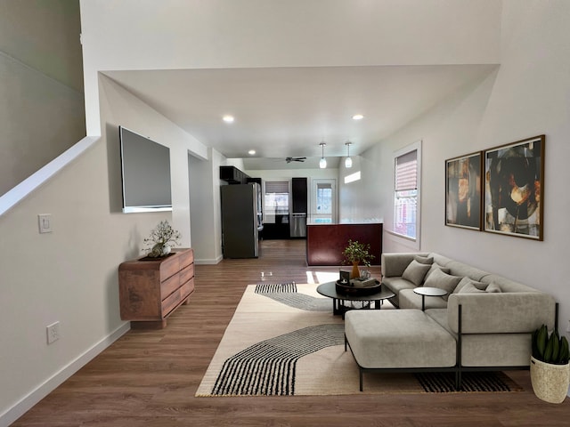 living area with dark wood-type flooring, baseboards, and recessed lighting