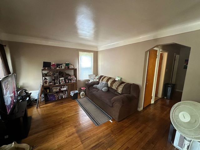 living room featuring arched walkways and wood finished floors