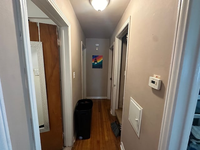 hall with baseboards and wood finished floors