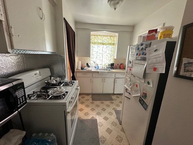 kitchen featuring white appliances, white cabinets, decorative backsplash, light countertops, and a sink