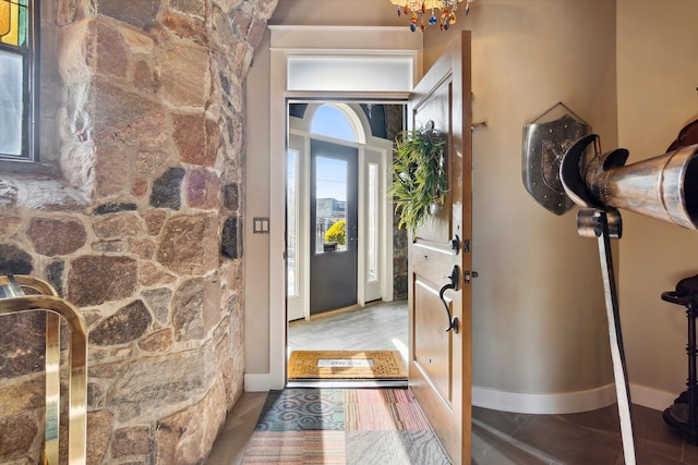 entryway featuring a chandelier and baseboards