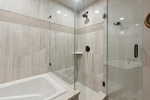 bathroom with a stall shower and a garden tub