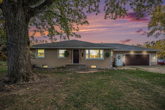 view of front of property featuring a garage, a lawn, driveway, and a shingled roof