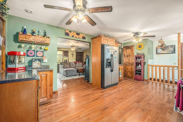 kitchen featuring light wood-type flooring, ceiling fan, and stainless steel refrigerator with ice dispenser