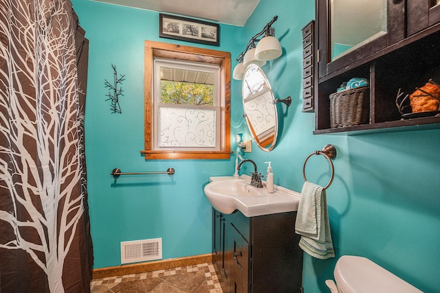 bathroom featuring baseboards, visible vents, vanity, and toilet