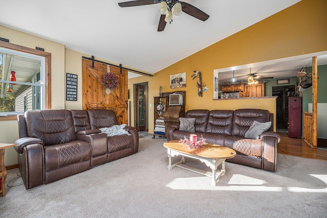 living room with lofted ceiling, carpet flooring, ceiling fan, and a barn door