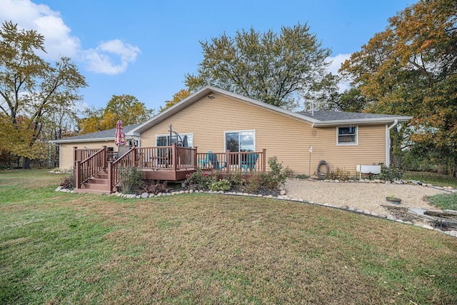 rear view of house with a deck and a lawn