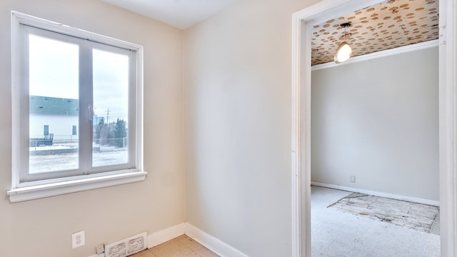 unfurnished room with baseboards and visible vents