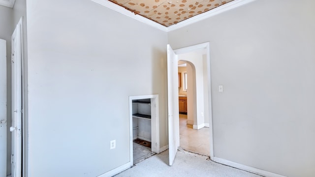 unfurnished bedroom with baseboards, arched walkways, and crown molding