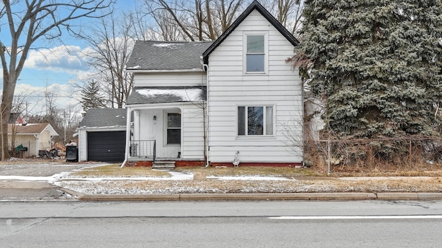 view of front of house featuring a garage, roof with shingles, and driveway