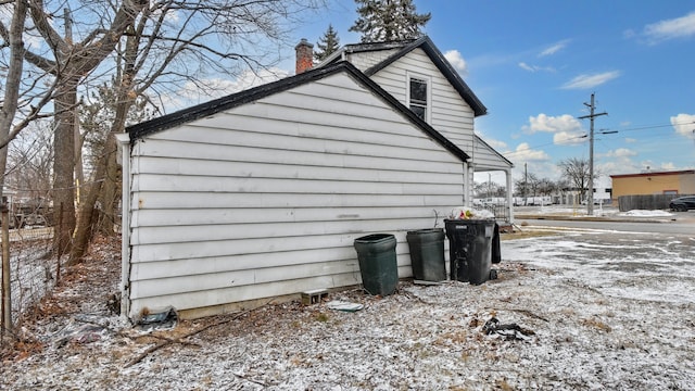 view of snow covered exterior with a chimney