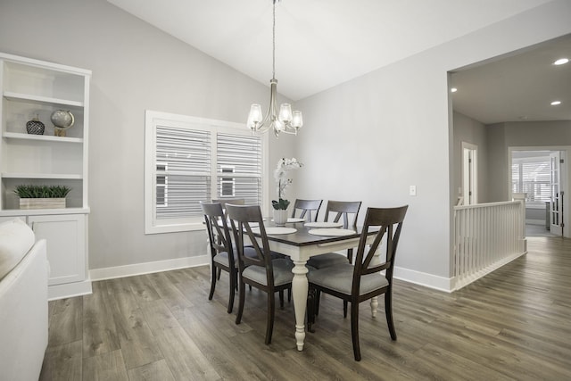 dining room featuring lofted ceiling, baseboards, an inviting chandelier, and wood finished floors