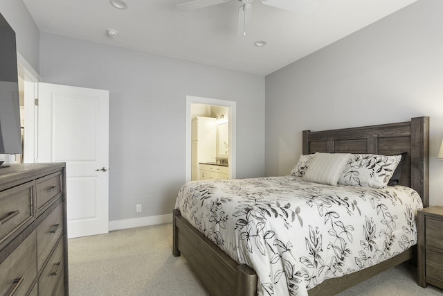 bedroom featuring light carpet, ceiling fan, baseboards, and connected bathroom