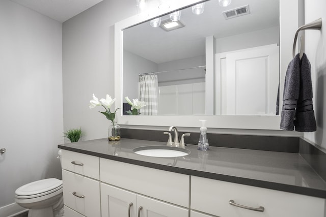 bathroom featuring toilet, a shower with shower curtain, vanity, and visible vents