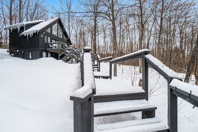 snow covered deck featuring stairs