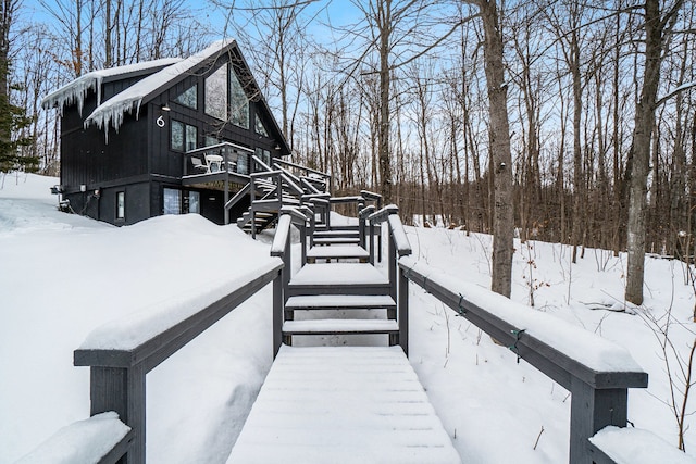 view of snow covered exterior with a deck and stairway