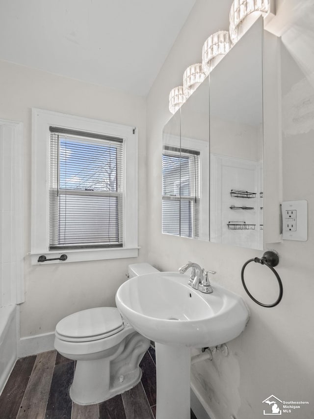 bathroom featuring toilet, baseboards, vaulted ceiling, and wood finished floors