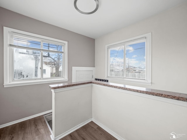 interior space featuring plenty of natural light, baseboards, and dark wood finished floors