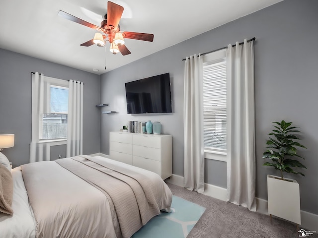 carpeted bedroom with ceiling fan and baseboards